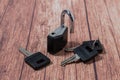 Black steel padlock with keys on a wooden background. Concept of security and tranquility Royalty Free Stock Photo