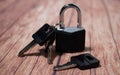 Black steel padlock with keys on a wooden background. Concept of security and tranquility Royalty Free Stock Photo