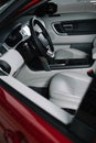 Black steering wheel and grey seats in red automobile.