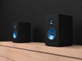 Black stereo Speakers with blue drivers on shelf