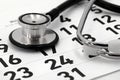 black stethoscope on calendar page, concept for scheduling a doctor's appointment or annual checkup Royalty Free Stock Photo