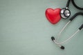 Black stethoscope with red heart of doctor for check up on light green background. Royalty Free Stock Photo