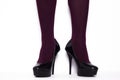 Black stilettos with high heels and purple stockings.