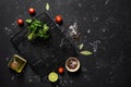 Black stone background with food  spices  vegetables  greens and oil. Ingredients for cooking. Top view  copy space Royalty Free Stock Photo