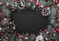 Black stone background with a frame of fir branches decorated with balls and red ribbon. Pine cones Royalty Free Stock Photo