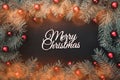 Black stone background with a frame of fir branches decorated with balls and red ribbon. Top view Royalty Free Stock Photo