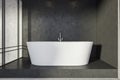 Black stone bathroom with oval white tub