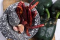 Black stone mortar with ingredients for sauce, red chili peppers, raw garlic cloves Royalty Free Stock Photo