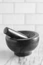 Black Stone Mortar and Pestle on a Marble Countertop Royalty Free Stock Photo