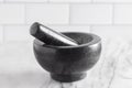 Black Stone Mortar and Pestle on a Marble Countertop Royalty Free Stock Photo