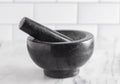 Black Stone Mortar and Pestle on a Marble Countertop Royalty Free Stock Photo