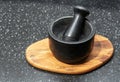 Black stone mortar and pestle on a wooden stand Royalty Free Stock Photo