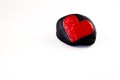 Black stone with a painted red heart isolated on white background Royalty Free Stock Photo