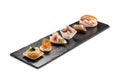 Black stone rectangular tray with shrimp tartare snack cannoli swordfish ravioli with robbiola tartina nordica mousse aubergine Royalty Free Stock Photo