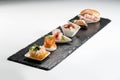 Black stone rectangular tray with shrimp tartare snack cannoli swordfish ravioli with robbiola tartina nordica mousse aubergine Royalty Free Stock Photo