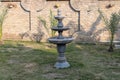 Black stone three-tier water fountain in the court yard Royalty Free Stock Photo