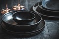 Black stoneware plates and bowls on a rustic black table Royalty Free Stock Photo