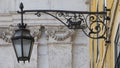 A black street lamp whose holder incorporates two ravens on a boat, the symbol of Lisbon.