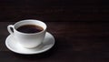 Black strong espresso coffee in a white ceramic cup. Wooden dark background, copy space Royalty Free Stock Photo