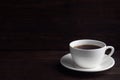 Black strong espresso coffee in a white ceramic cup. Wooden dark background, copy space Royalty Free Stock Photo