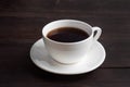 Black strong espresso coffee in a white ceramic cup. Wooden dark background, copy space Royalty Free Stock Photo