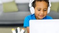 Black student child doing homework using computer literature while looking at the screen Royalty Free Stock Photo