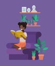 Black student girl sitting reading book in livingroom Royalty Free Stock Photo