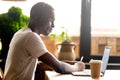 Black student studying using laptop and headphones Royalty Free Stock Photo