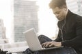 Black student typing in a computer in the city