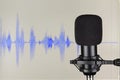 Black studio condenser microphone over waveform