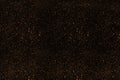 Black stylish background with a huge amount of gold dust particles sparkles. A fashionable base for your projects