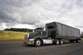 Black stylish big rig semi truck for local haul transporting car