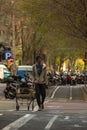 Black sub Saharan man with wool cap walking on the bike lane with his shopping cart looking for scrap from the rubbish bins to Royalty Free Stock Photo