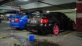 Black Subaru WRX STI and Blue Mitsubishi Lancer Evolution VI in an underground parking lot Royalty Free Stock Photo