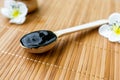 Black substance in wooden jar on a wooden background. Royalty Free Stock Photo