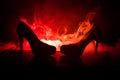 Black suede high heel women shoes on dark toned foggy background. Close up. Women power or women domination concept.