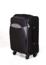 black roller suitcase on white floor in front of white studio background