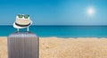 Black suitcase with hipster hat and sunglasses on tropical sea and sandy beach a in background. Summer holiday traveling design Royalty Free Stock Photo