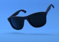 Black summer sunglasses falling down on a pastel bright blue background Royalty Free Stock Photo