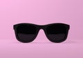 Black summer sunglasses falling down on a pastel bright pink background Royalty Free Stock Photo