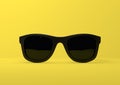 Black summer sunglasses falling down on a pastel bright yellow background Royalty Free Stock Photo
