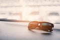 Black sunglasses on the front console of car on traveling. Soft and split cross processing tone to retro vintage pinterest and Royalty Free Stock Photo