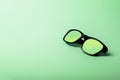 Black sunglasses with Multicolor Mirror Lens on green background. Polarized sunglasses with UV protection. Royalty Free Stock Photo