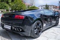 Black supercar Lamborghini with shiny stripes sitting parked in the city