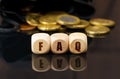 On a black surface are coins and cubes with the inscription - FAQ Royalty Free Stock Photo