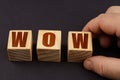 On a black surface, a man puts cubes with the inscription - WOW Royalty Free Stock Photo