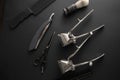 On a black surface are old barber tools. two vintage manual hair clipper, comb, razor, shaving brush, hairdressing scissors. black Royalty Free Stock Photo