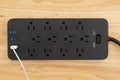 Surge protector with USB protection on wood desk Royalty Free Stock Photo