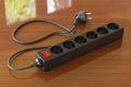 Black surge protector or spike suppressor on the wooden table, 3D rendering Royalty Free Stock Photo