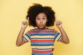 Black surprised girl with curly hair pointing fingers upward